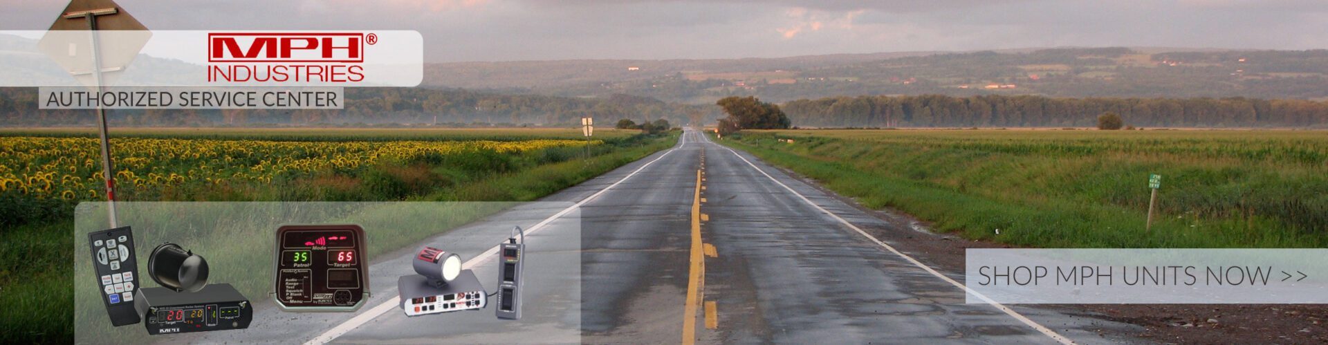 A road with a green field and a yellow sign