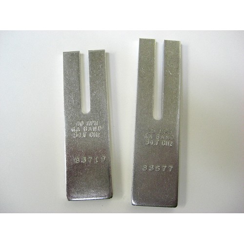 A pair of metal blades for a sewing machine.