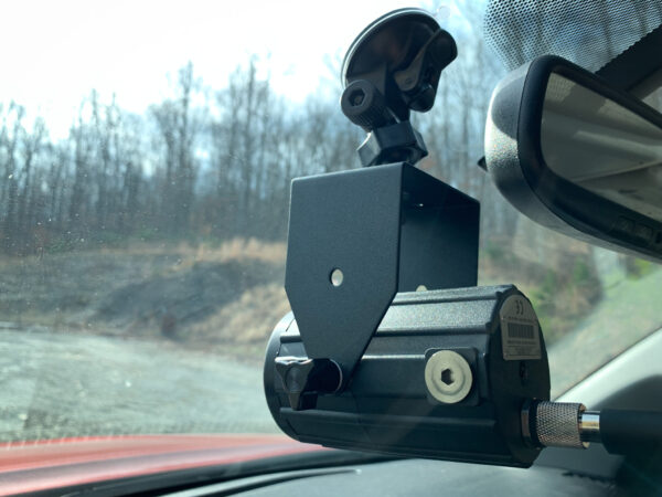 A car camera is mounted to the side of the windshield.