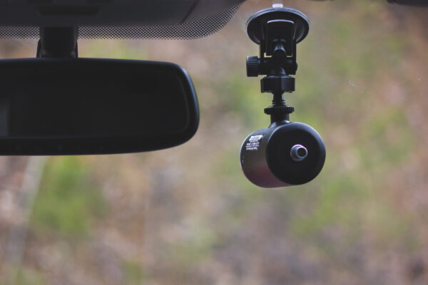 A car camera is hanging on the side of the road.
